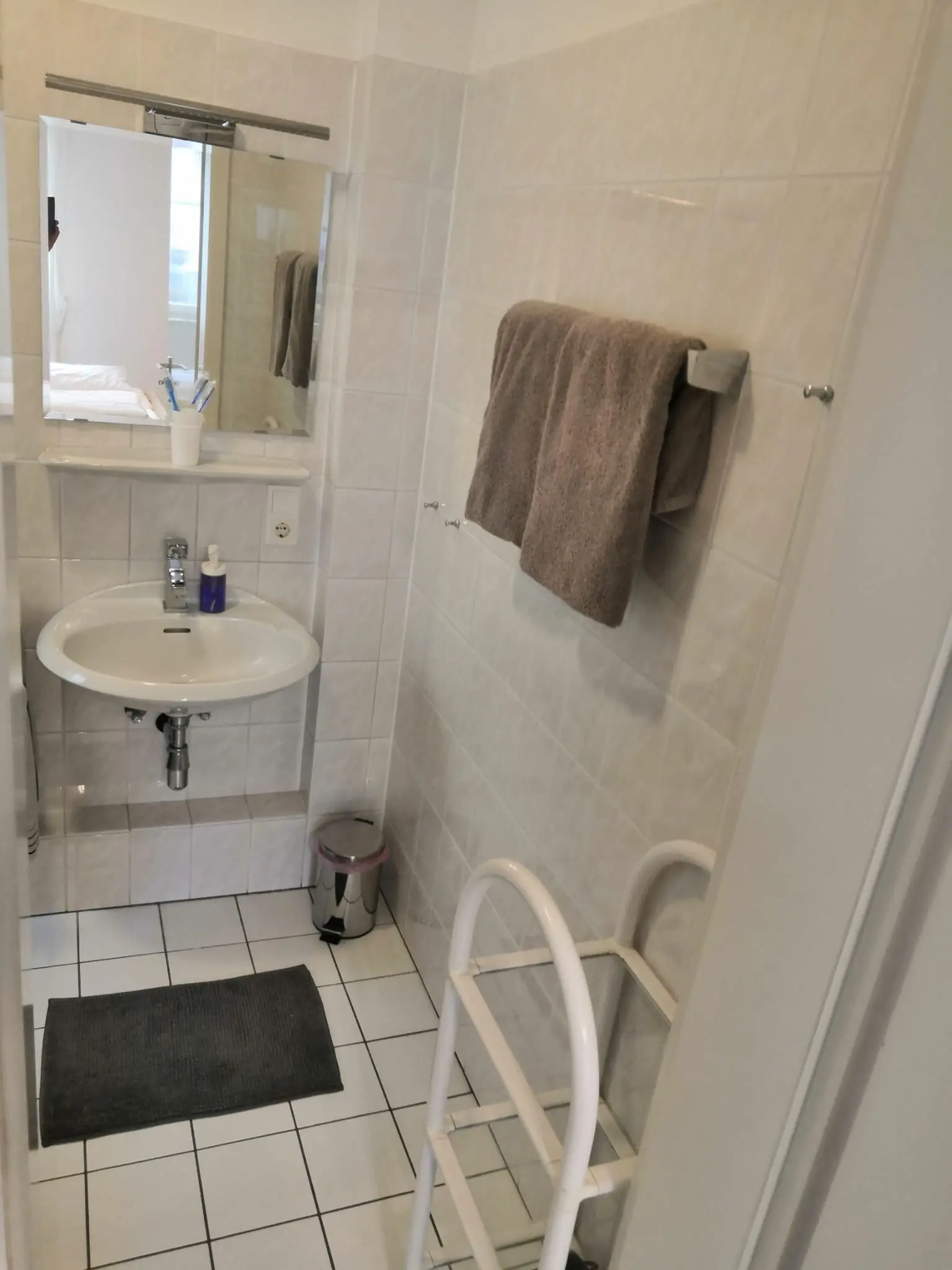 Waschbecken mit Spiegel und Handtuch