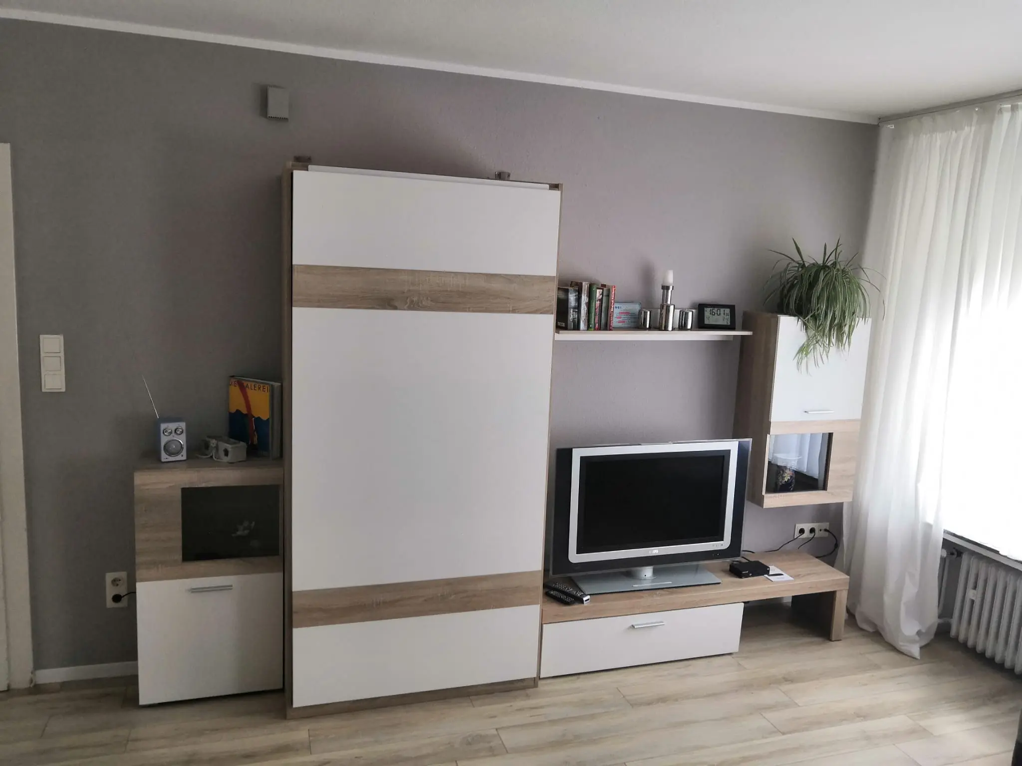 Wohnzimmer mit Schrankwand und Fernseher