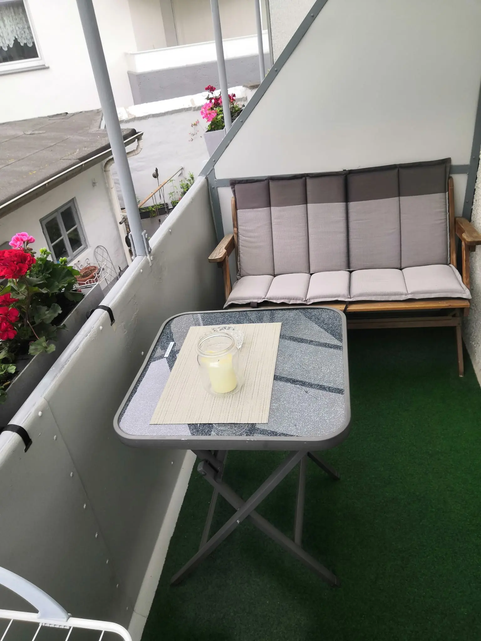Balkon mit Sitzbank und Blumen