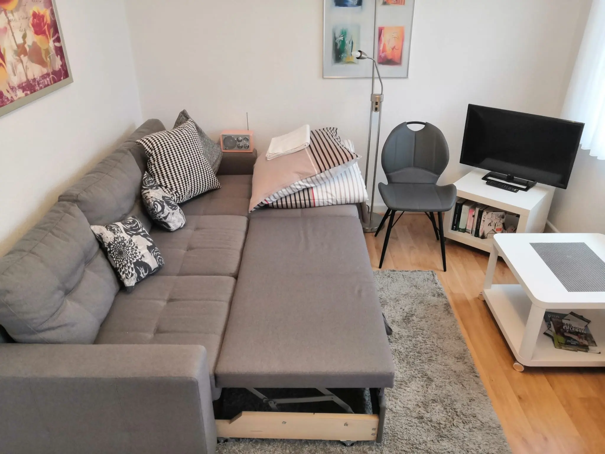 Ausgeklapptes Schlafsofa mit Bettwäsche