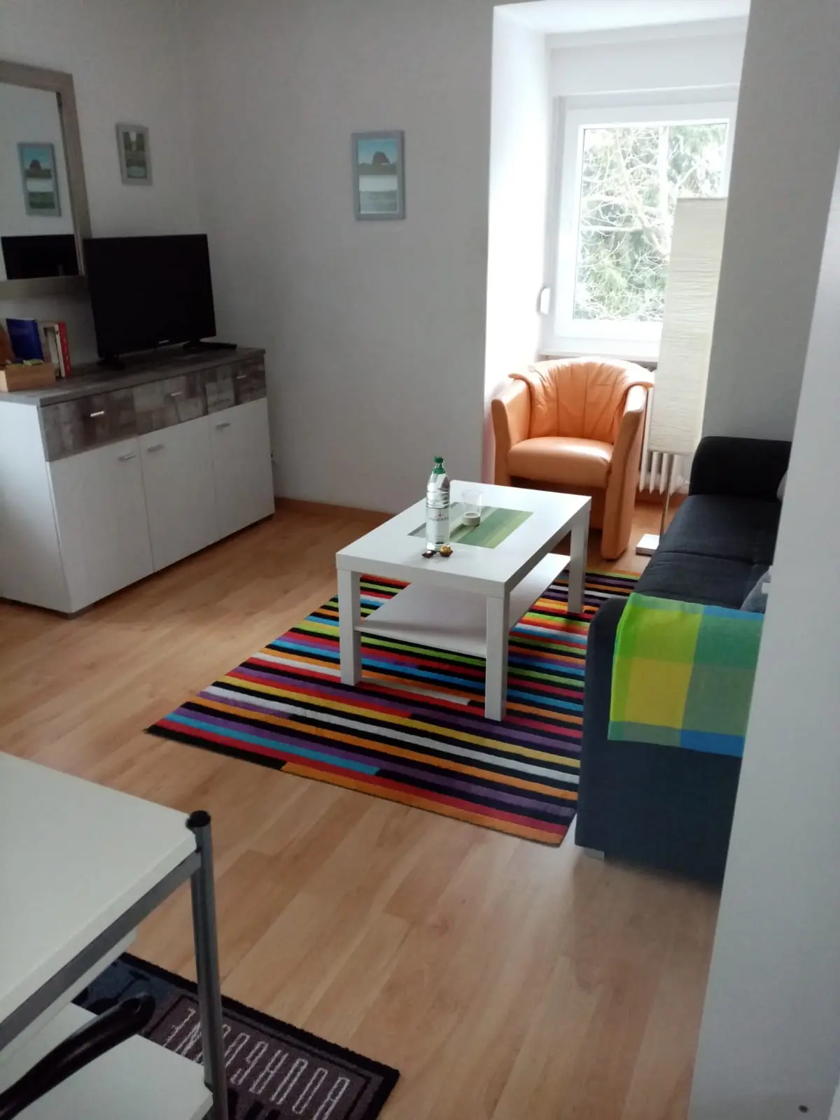 Wohnzimmer mit Kommode und Fernseher in der Ferienwohnung 4 in Bad Pyrmont