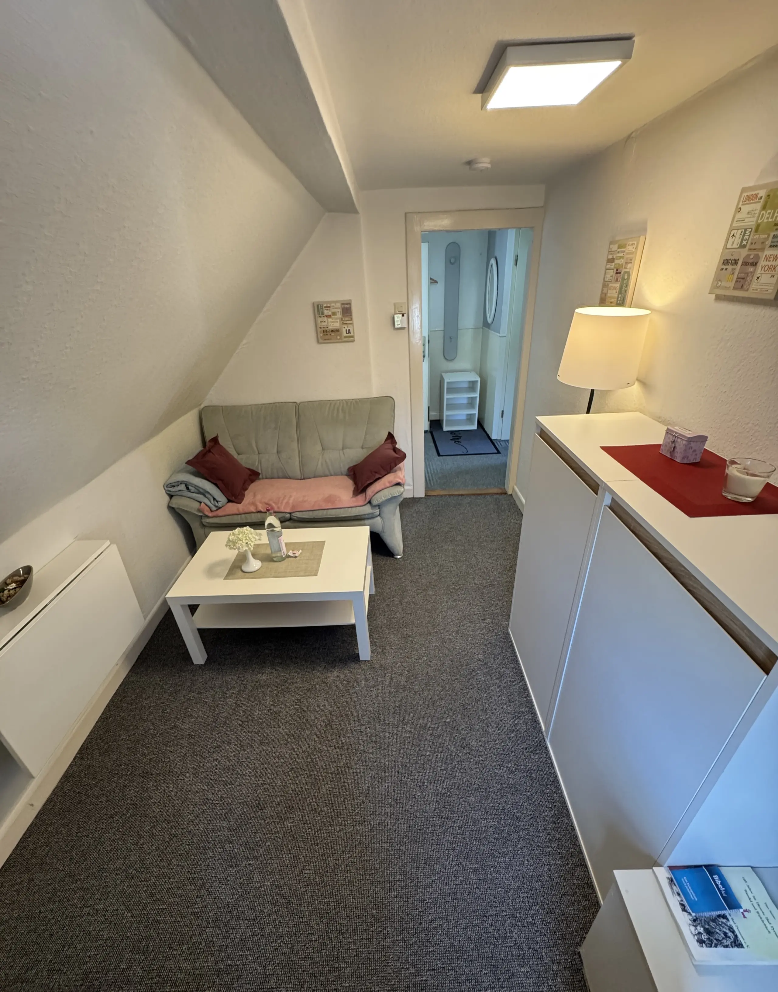 Wohnzimmer mit Sofa und Blick in die Diele der Ferienwohnung 6 in Bad Pyrmont