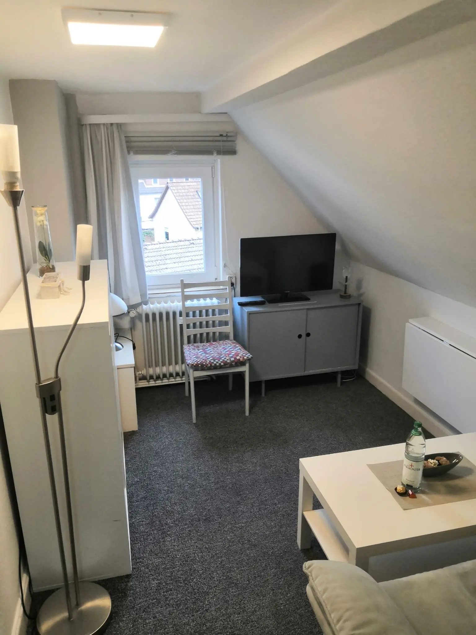 Wohnzimmer mit Fernseher und Kommode in der Ferienwohnung 6 in Bad Pyrmont